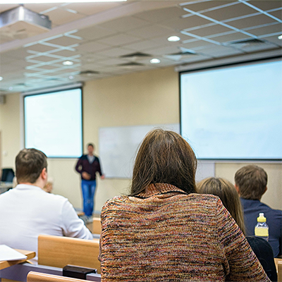 Person offering a crime prevention presentation to a group of students.